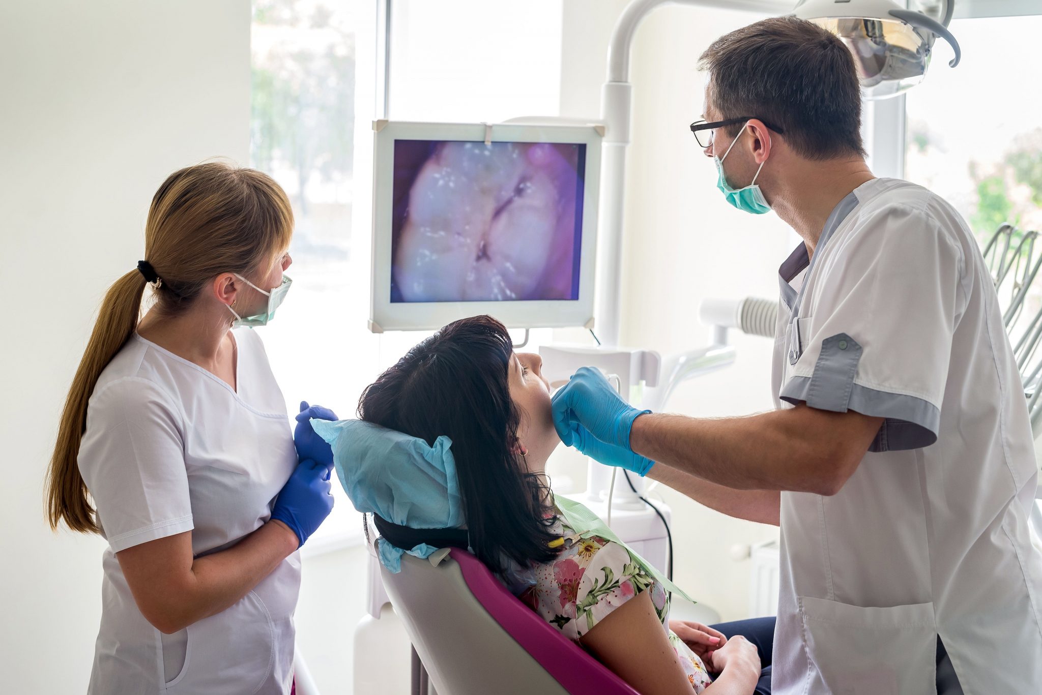 Rosenthal Dentist Looking At Monitor While Working On Woman Patient